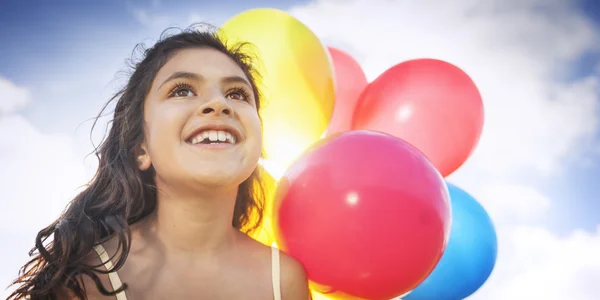 Девушка играет с красочными воздушными шарами — стоковое фото