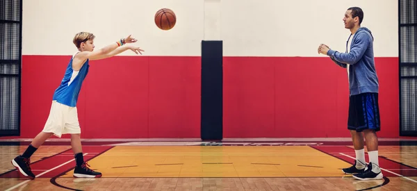 Esportista ensinando menino jogar basquete — Fotografia de Stock