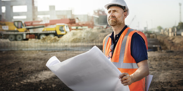 Строитель рассматривает план строительства
