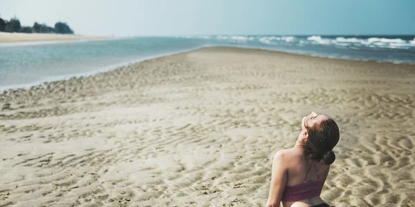 Kumsalda yoga yapan bir kadın. — Stok fotoğraf