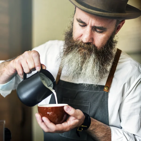 Бариста наливает молоко в кофе — стоковое фото