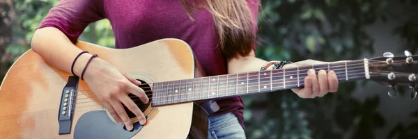 Vrouw die gitaar speelt Rechtenvrije Stockfoto's