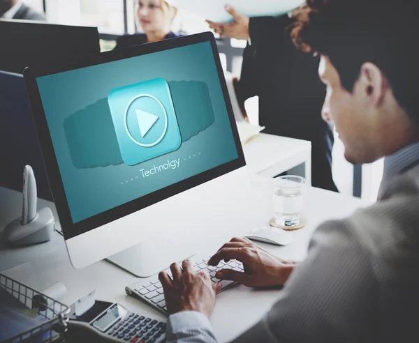 Businessman working on computer with player — Stock Photo, Image