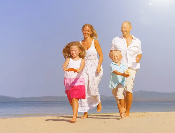 Счастливая семья с детьми на пляже — стоковое фото