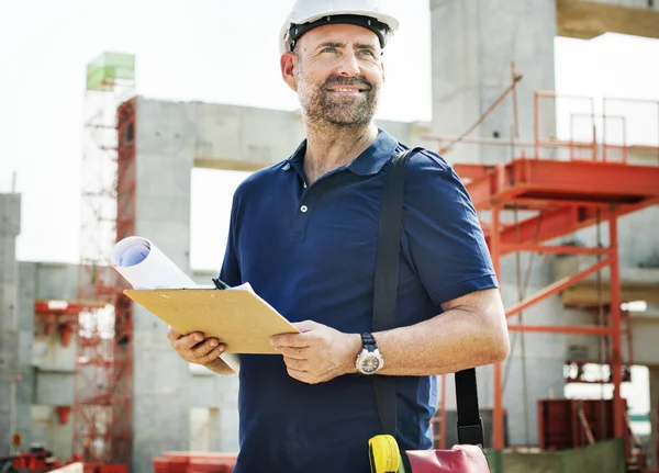 Travailleur de la construction regardant le plan du bâtiment — Photo