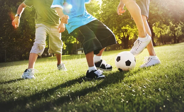 Father playing football with sons — Stockfoto