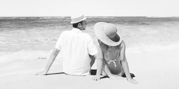 Пара сидящих на пляже — стоковое фото