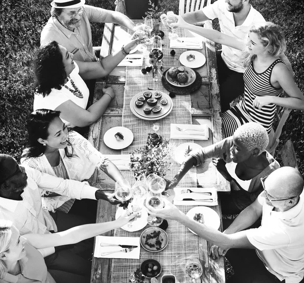 Pessoas sentadas à mesa e comemorando — Fotografia de Stock