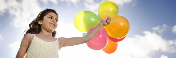 Menina brincando com balões coloridos — Fotografia de Stock