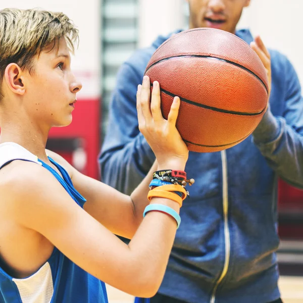 Sportler lehrt Jungen Basketball spielen — Stockfoto