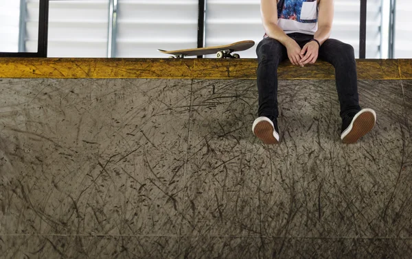 Man sittplatser med skateboard — Stockfoto