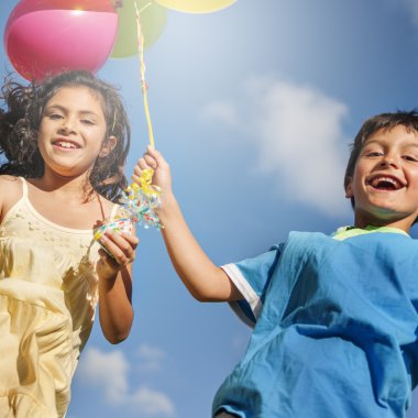 Çocuklar renkli balonlarla oynuyorlar.