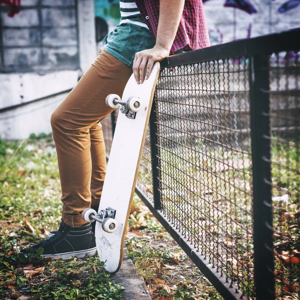 Muž držící skateboard — Stock fotografie