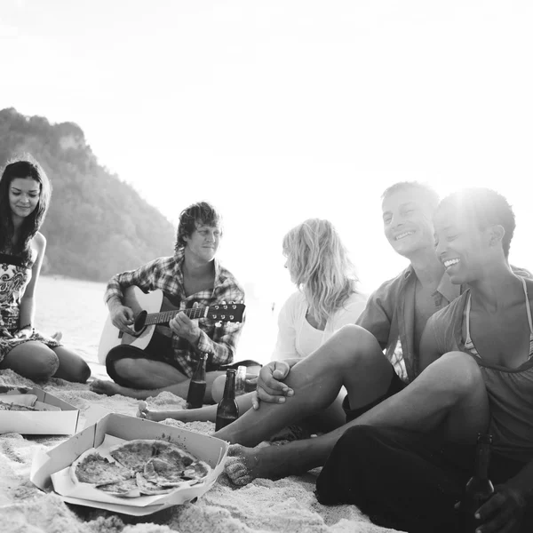 Vrienden pizza eten op het strand — Stockfoto