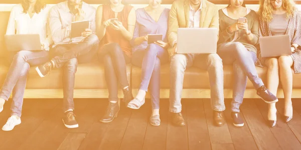 Menschen sitzen mit digitalen Geräten — Stockfoto