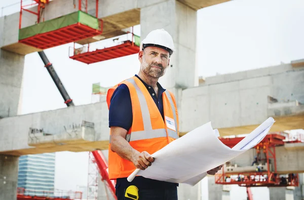 Konstruktion arbetaren tittar på Byggnadsplan — Stockfoto