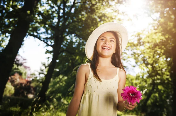 Menina com flor no parque — Fotografia de Stock