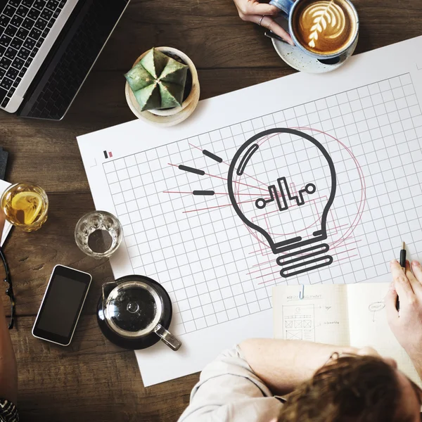 Table with poster with bulb — Stock Photo, Image