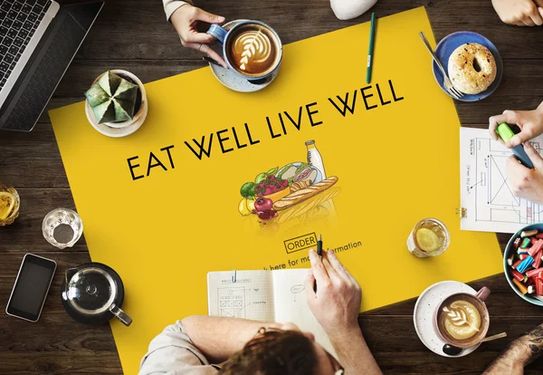 Table with poster with Eat Well — Stock Photo, Image