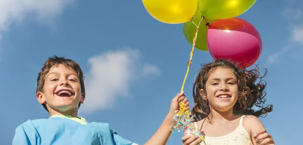 Niños jugando con globos de colores — Foto de Stock