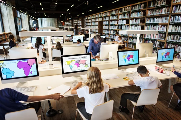 Grupo de crianças que estudam na biblioteca — Fotografia de Stock