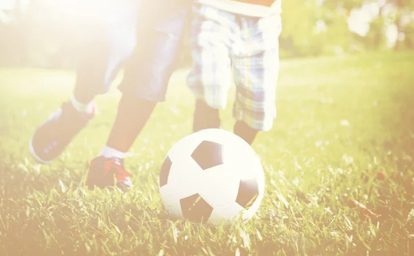 Barn spelar fotboll i sommar park — Stockfoto