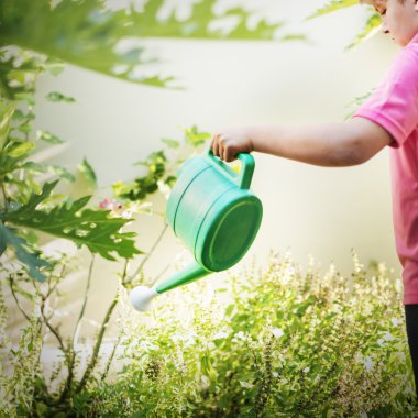 Çiçekleri sulayan çocuk