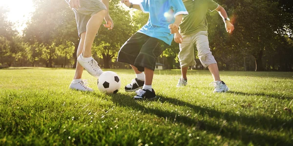Father playing football with sons — Stockfoto