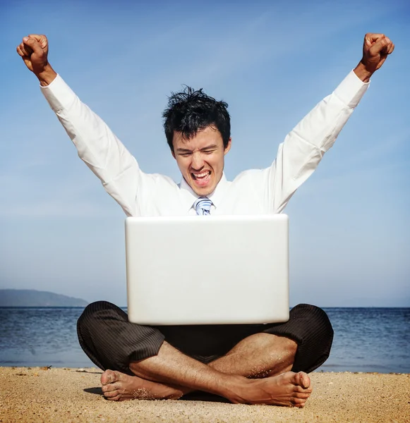 Zakenman aan strand met laptop — Stockfoto