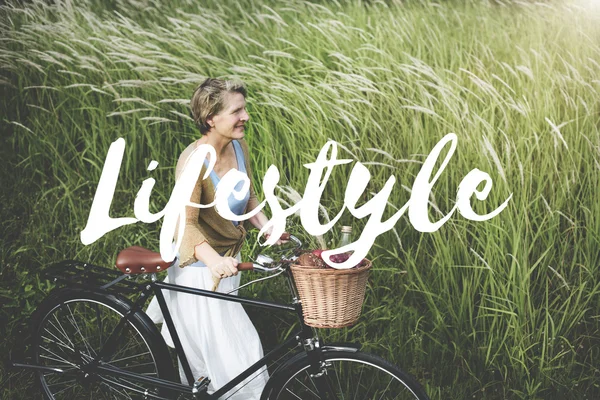 Mulher com bicicleta no campo — Fotografia de Stock