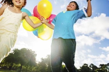 Çocuklar renkli balonlarla oynuyorlar.
