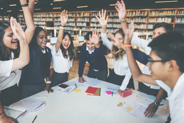 Estudantes felizes na biblioteca universitária — Fotografia de Stock