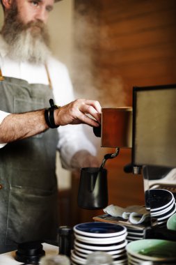 Kafede kahve yapan barista.