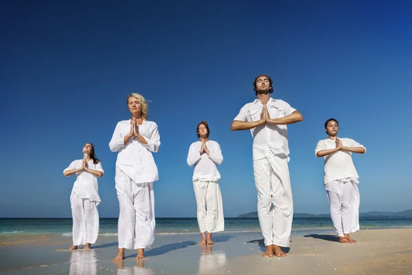 Люди, що виконують йогу на пляжі — стокове фото