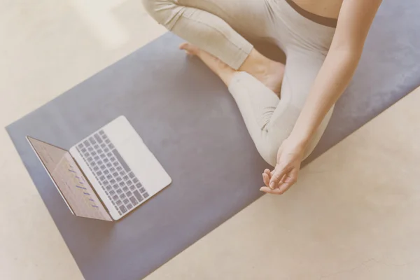 Portrait of woman doing yoga with laptop — Stock Photo, Image