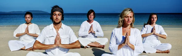Pessoas meditando na praia — Fotografia de Stock