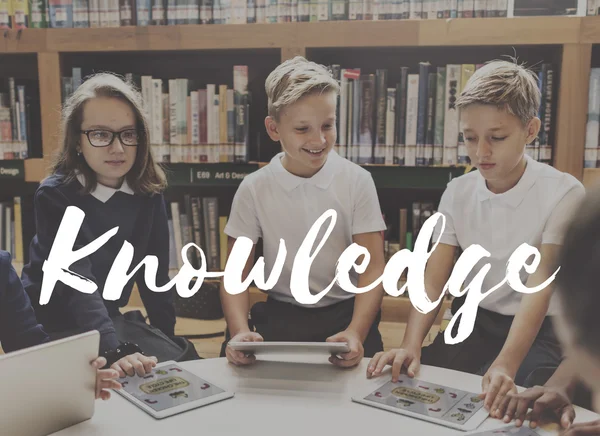 Enfants avec appareils numériques dans la bibliothèque — Photo