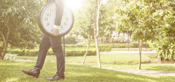 Бізнесмен тримає великий годинник — стокове фото