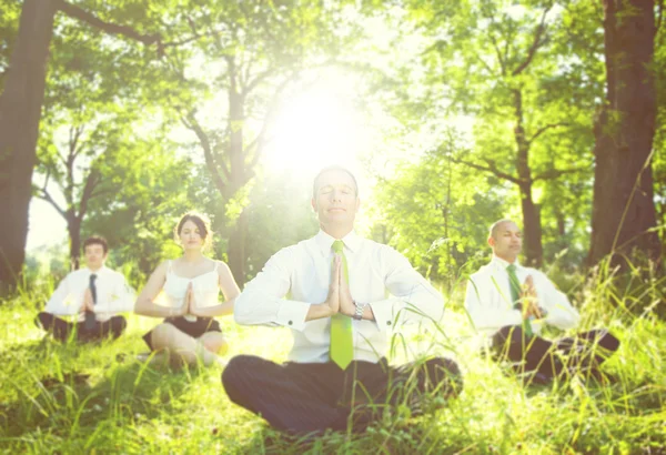 Business people meditating outdoors — Stockfoto