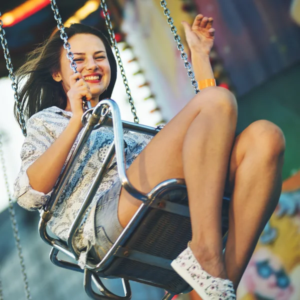 Meisje paardrijden op schommel in attractiepark — Stockfoto