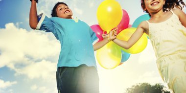 Çocuklar renkli balonlarla oynuyorlar.