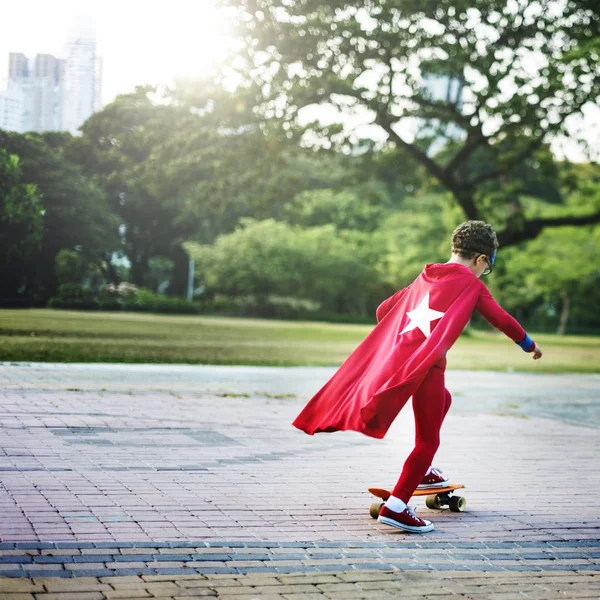 Superhero Kid montando no skate — Fotografia de Stock