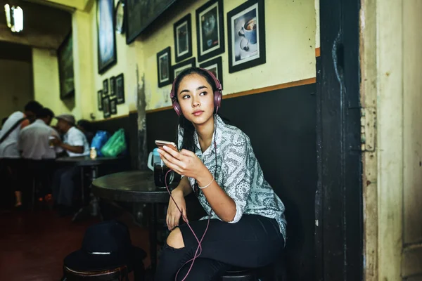 Femme écouter de la musique dans un café — Photo