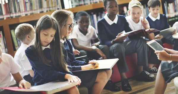 Klasgenoten lezen in de bibliotheek — Stockfoto