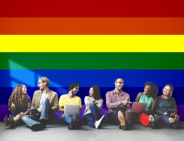 Diversidade amigos perto da parede com arco-íris — Fotografia de Stock