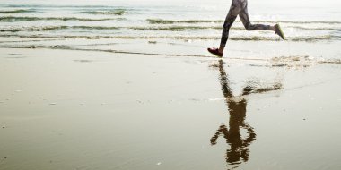 Sahilde egzersizleri yapıyor kadın