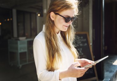 Tablet kullanan genç bir kadın.
