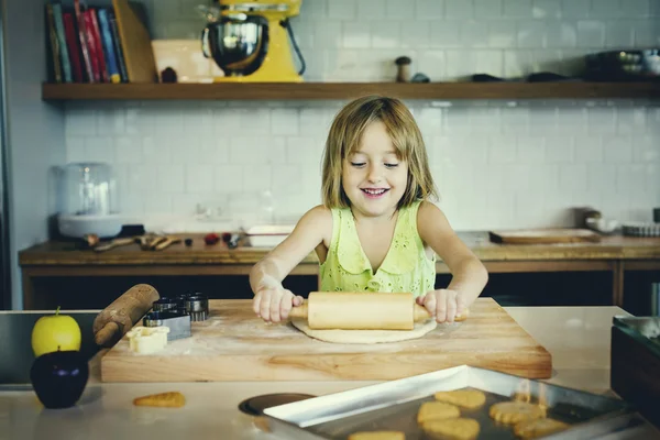 Menina amassando massa de farinha de biscoitos — Fotografia de Stock
