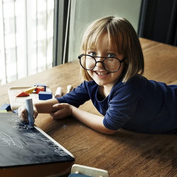 Little Girl writing on blackboard — Stock Photo, Image