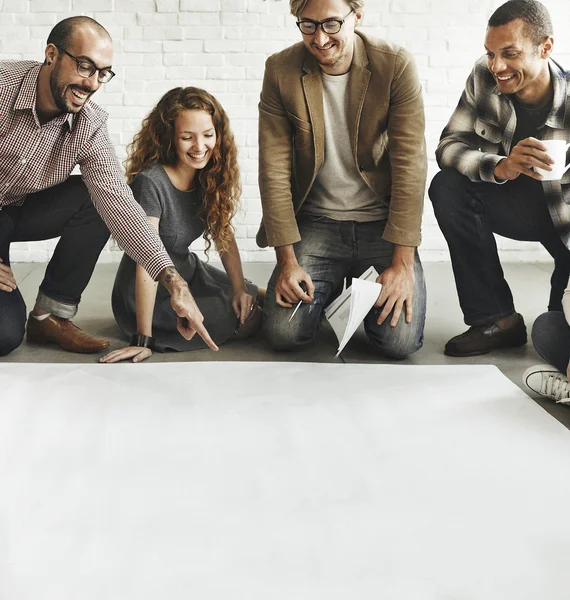 Diseñadores trabajando con póster en blanco — Foto de Stock